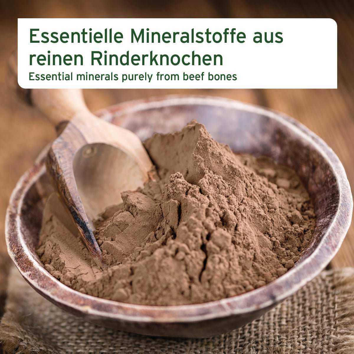Gemahlene Rinderknochen in Holzschale mit Holzlöffel, hochwertige Calciumquelle für Hunde und Katzen.