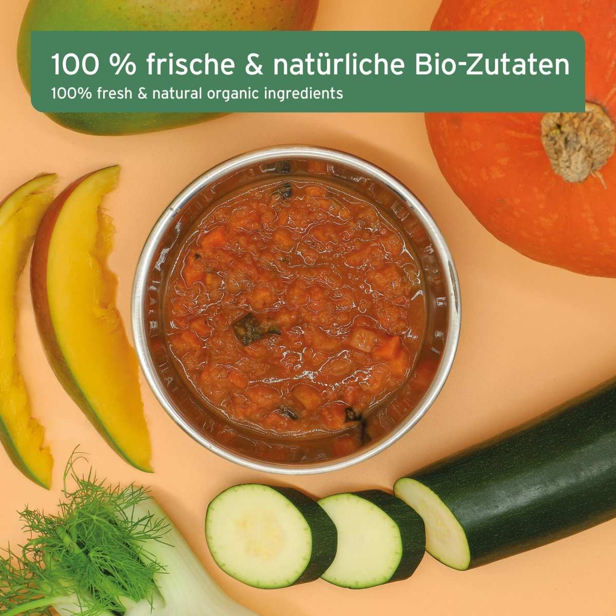 Bio BARF-Püree mit Fenchel und Mango in einer Schale, umgeben von frischem, biologischem Gemüse und Obst.